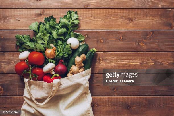 fresh vegetables in the eco cotton bag at the kitchen counter - vegetable stock pictures, royalty-free photos & images