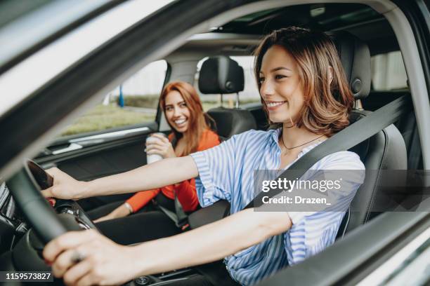donne millenarie che condividono un giro in auto - convenienza foto e immagini stock