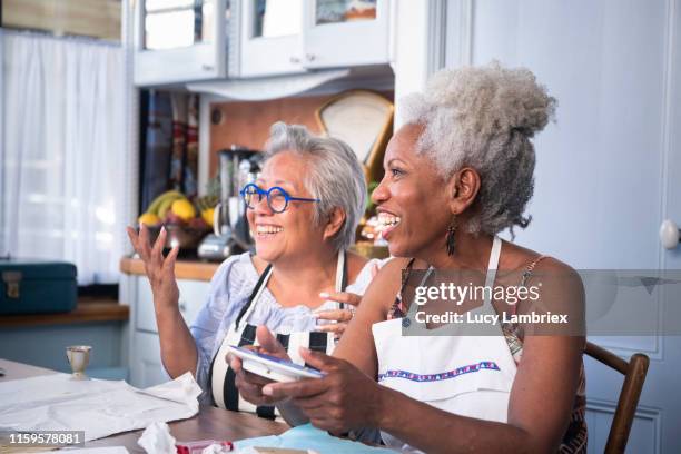 two women laughing and joking at a new kintsugi workshop: fixing broken ceramics with golden glue - brille kaputt stock-fotos und bilder