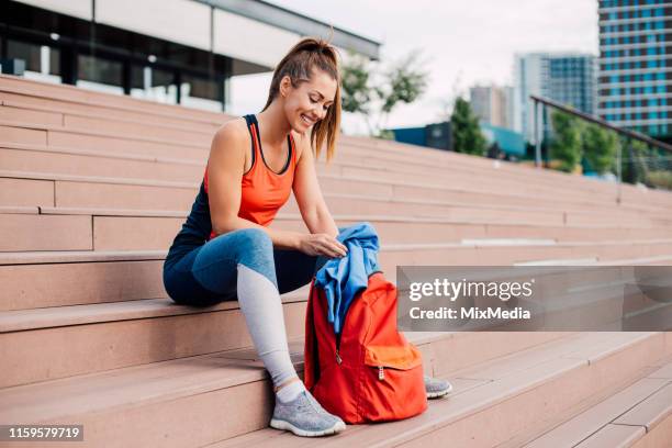 chica sacando ropa de la bolsa del gimnasio - gym bag fotografías e imágenes de stock