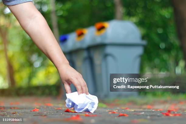 hand woman picking up garbage on the floor. recycling bin on background - pick up paper stock pictures, royalty-free photos & images