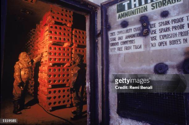 Worker in protective clothing stands in a special storage area filled with M-55 rockets armed with sarin gas, a nerve agent, at an incinerator June...