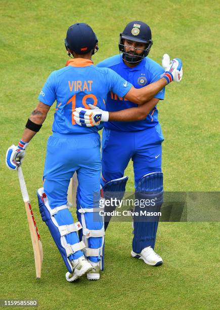Rohit Sharma of India celebrates his century with incoming batsman and captain Virat Kohli of India during the Group Stage match of the ICC Cricket...