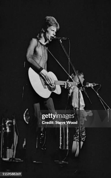David Bowie performing at the Hammersmith Odeon, at the last of his Ziggy Stardust concerts, London, 3rd July 1973. On the right is guitarist Mick...