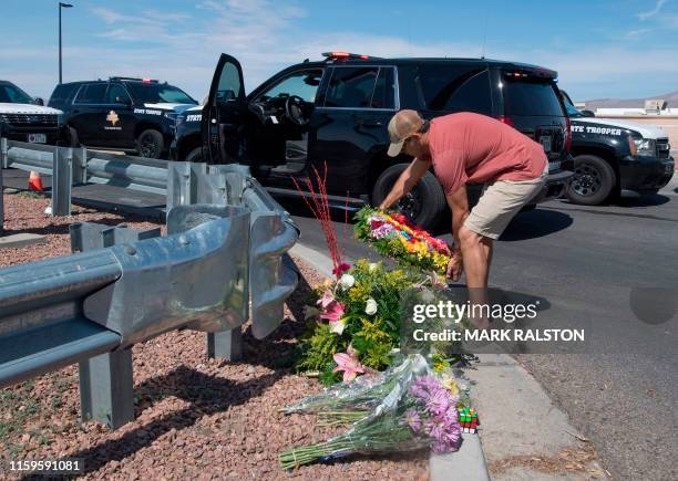 Man places flowers at a makeshift memorial outside the Cielo Vista Mall Wal-Mart where a shooting left 20 people dead in El Paso, Texas, on August 4,...