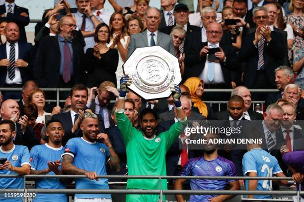 Manchester City's Chilean goalkeeper Claudio Bravo raises the trophy after winning the English FA Community Shield football match between Manchester...