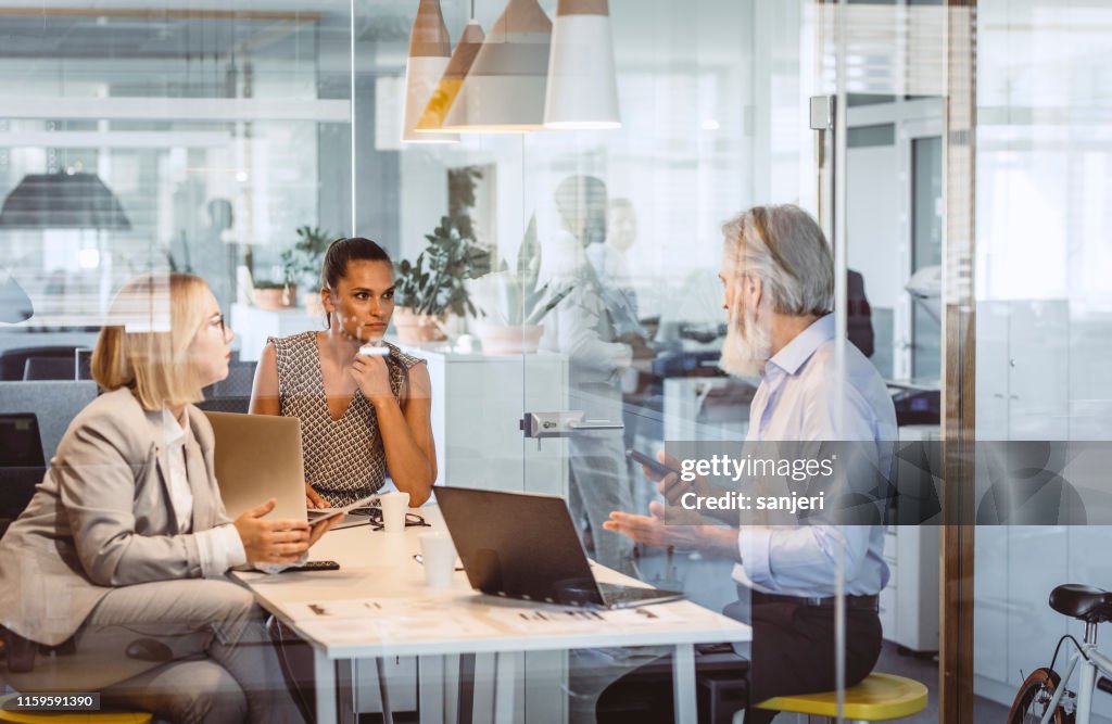 Zakelijke mensen zitten aan de balie, bespreken