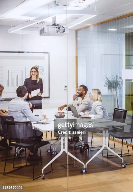 business people having a meeting in the board room - meeting room presentation stock pictures, royalty-free photos & images