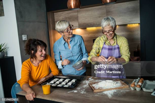 senior friends make a cake in the kitchen - woman making cake stock pictures, royalty-free photos & images