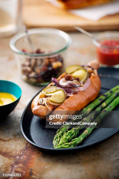artisan hot dog in brioche bun with grilled asparagus. - relish stock pictures, royalty-free photos & images
