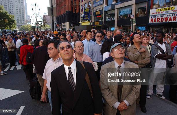 Spectators look up as the World Trade Center goes up in flames September 11, 2001 in New York City after two airplanes slammed into the twin towers...