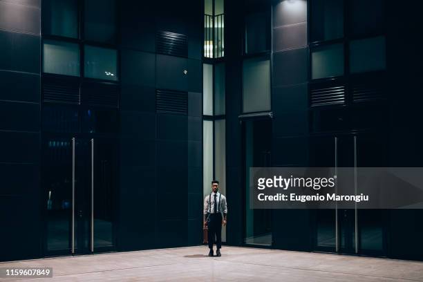 businessman standing in front of office building, milano, lombardia, italy - night before fotografías e imágenes de stock