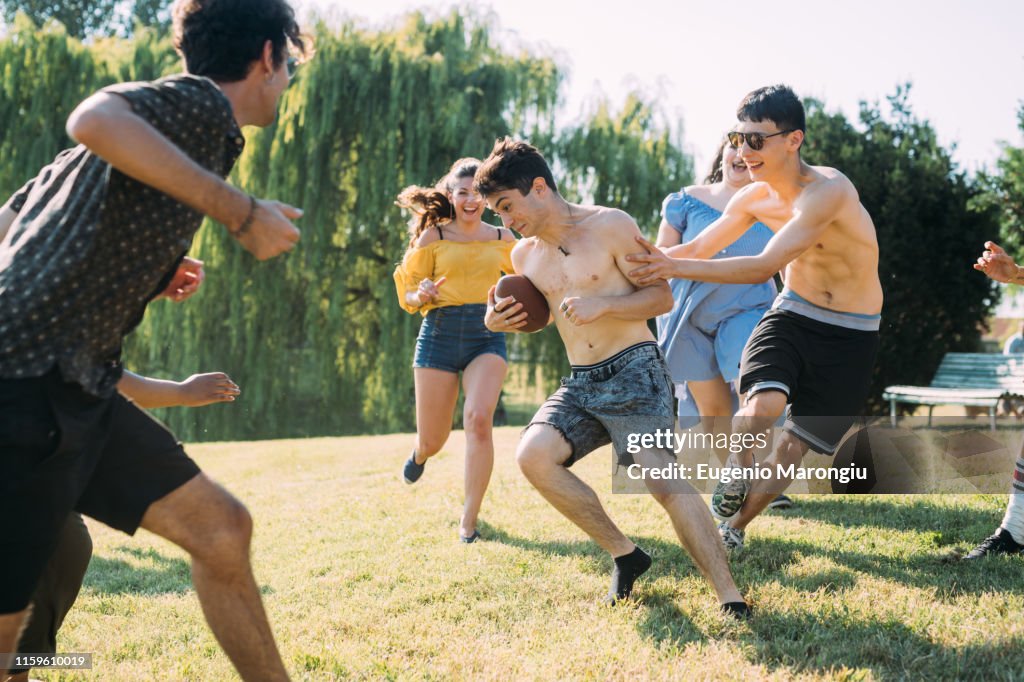 Group of friends playing football in park