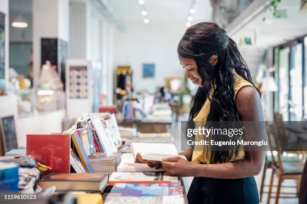 young businesswoman browsing book in bookshop - alternative people ストックフォトと画像
