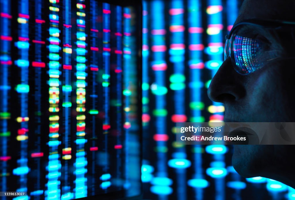 Genetic Research, scientist viewing DNA information on screens