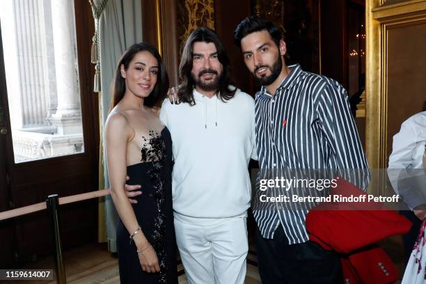 Designer Stephane Rolland poses between Sofia Essaidi and her husband Adrien Galo after the Stephane Rolland Haute Couture Fall/Winter 2019 2020 show...