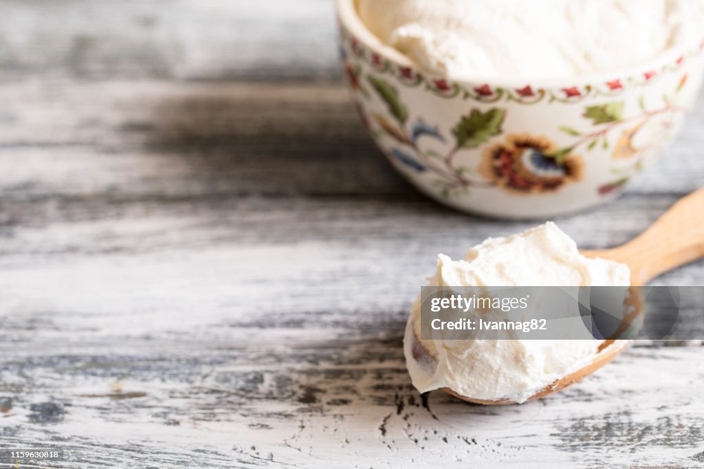 Fresh homemade mascarpone. Traditional Mascarpone cheese in wooden spoon