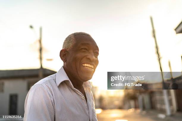 smiling afro senior man looking away on the street - man side way looking stock pictures, royalty-free photos & images