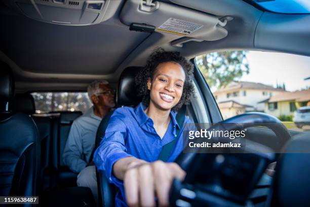 young black woman driving car for rideshare - uber driver stock pictures, royalty-free photos & images