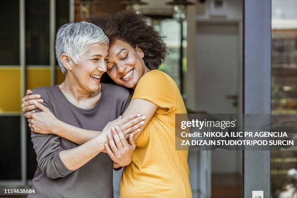 two beautiful woman embracing - generosity stock pictures, royalty-free photos & images
