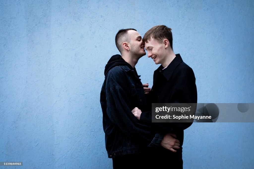 A young LGBT couple laughing and hugging