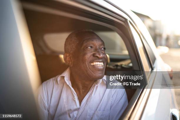 smiling senior car passenger looking out of window - car passenger stock pictures, royalty-free photos & images
