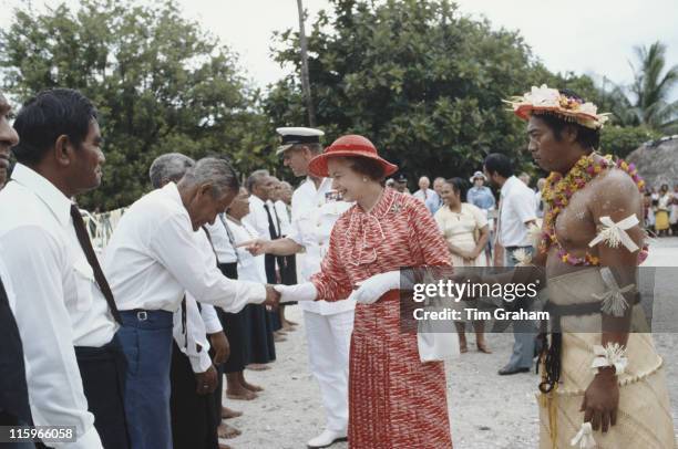 Queen Elizabeth ll and Prince Philip led by Ieremia Tabai, President of Kiribati, shaking hands as they meet local dignitaries on their arrival in...