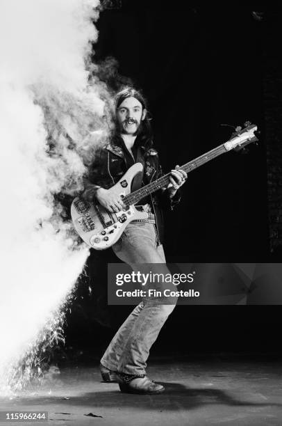 Lemmy Kilmister, British rock bassist and singer with British heavy metal band Motorhead, poses with his bass guitar with fireworks attached, firing...