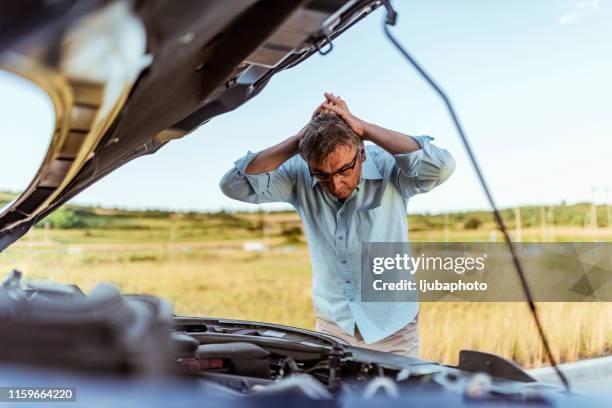 angry man checking his car - capô de carro imagens e fotografias de stock