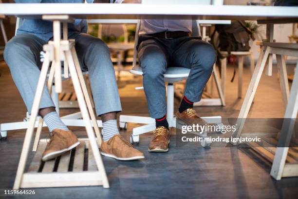 human legs in co-working space - lower employee engagement stock pictures, royalty-free photos & images