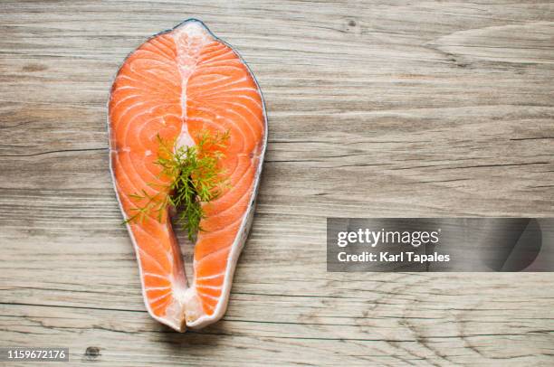 raw salmon steak garnished with dill on a wooden table - pubic hair stock pictures, royalty-free photos & images