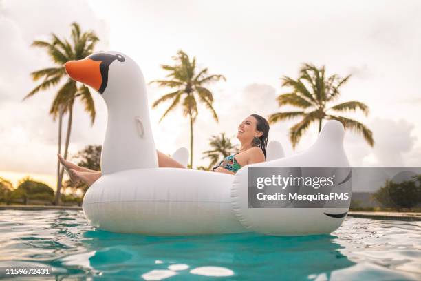 young woman relaxing in the pool - inflatable pool toys imagens e fotografias de stock