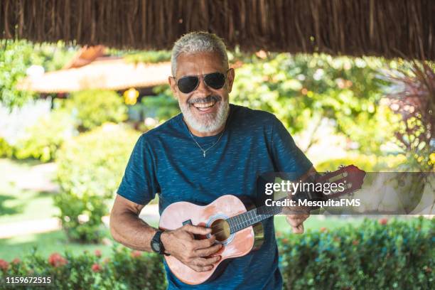 senior man playing cavaquinho - plucking an instrument stock pictures, royalty-free photos & images