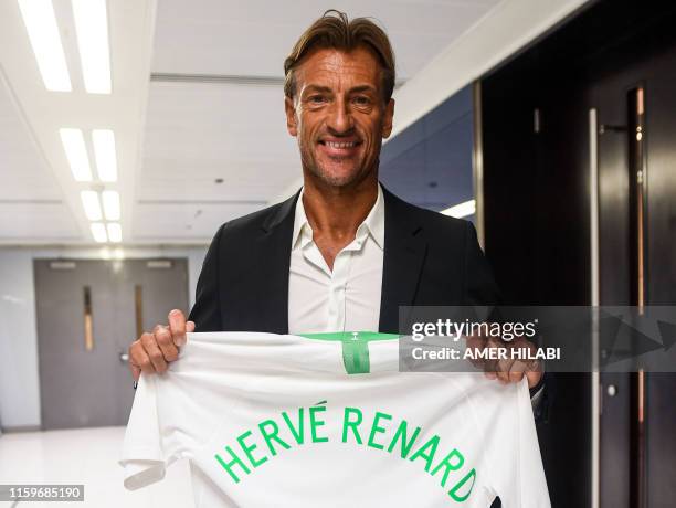 French football coach Herve Renard poses with a Saudi national football team jersey bearing his name, after signing on as coach, in the Red Sea...