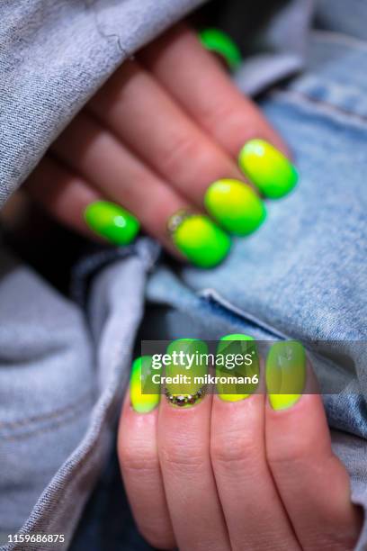 close-up of woman fingers with nail art manicure in neon green - ombré imagens e fotografias de stock