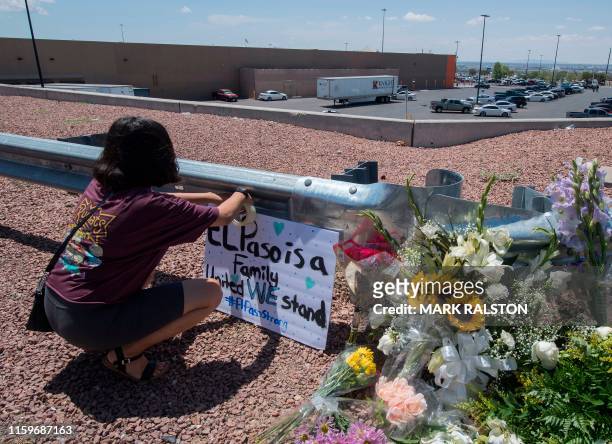 Woman places a Stay Strong sign beside a makeshift memorial outside the Cielo Vista Mall Wal-Mart where a shooting left 20 people dead in El Paso,...