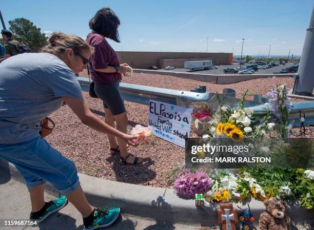 People place flowers beside a makeshift memorial outside the Cielo Vista Mall Wal-Mart where a shooting left 20 people dead in El Paso, Texas, on...