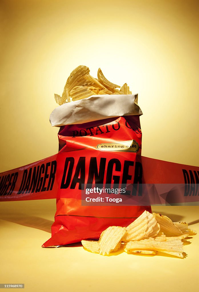 Danger tape around bag of potato chips
