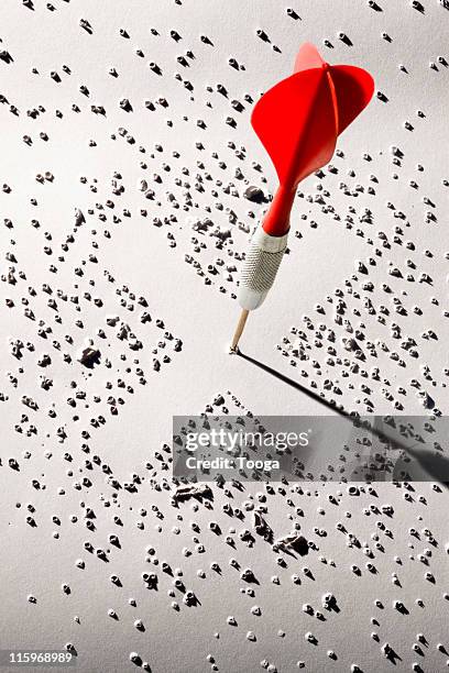 red dart hitting center of target - dartpfeil stock-fotos und bilder