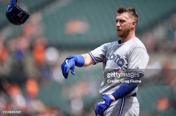 Justin Smoak of the Toronto Blue Jays tosses his helmet after striking out in the third inning against the Baltimore Orioles at Oriole Park at Camden...