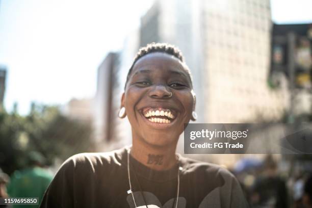 glückliche lesbische frau, die während der pride parade in die kamera schaut - daily life in sao paulo stock-fotos und bilder