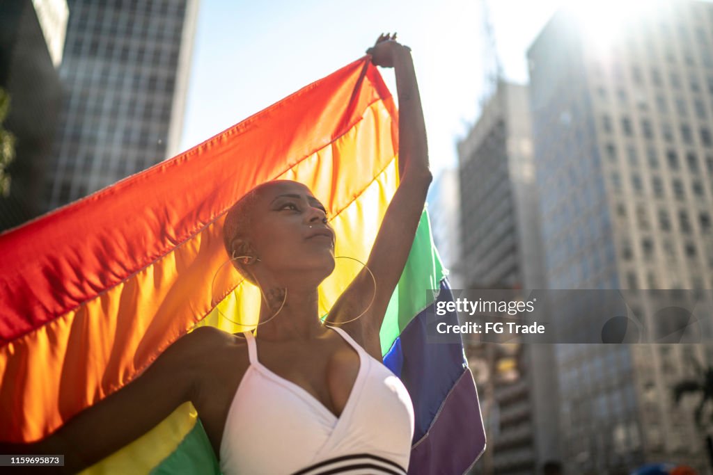 Confident lesbian woman holding rainbow flag during pride parade