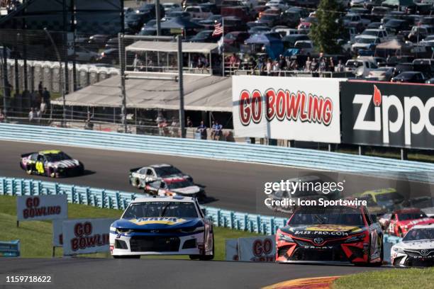 Hendrick Motorsports driver Chase Elliott and Joe Gibbs Racing driver Martin Truex Jr race up through turn 2 during a late race re-start in the...