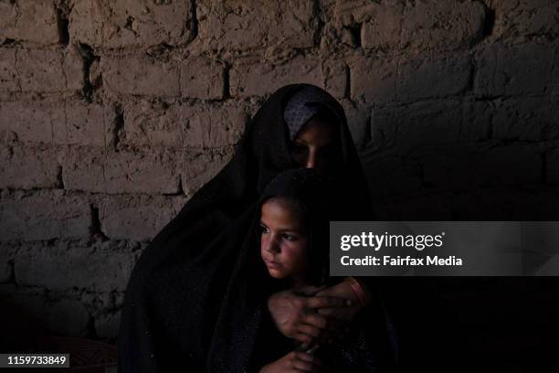 Six-year-old Farzana sits with her mother, Zarmina, in the family’s shelter in the Regreshan IDP camp in Herat Province, Afghanistan, June 17, 2019....