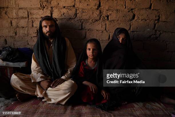 Abdul Nabi sits with his wife, Zarmina, and their 6-year-old daughter, Farzana, in their shelter at the Regreshan IDP camp in Herat Province,...