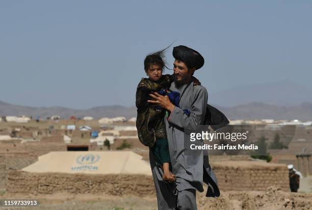 Abdul Haq carries his 4-year-old-daughter, Khadija, through the Regreshan IDP camp in Herat Province, Afghanistan, June 17, 2019. Abdul sustained...
