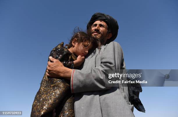 Abdul Haq carries his 4-year-old-daughter, Khadija, through the Regreshan IDP camp in Herat Province, Afghanistan, June 17, 2019. Abdul sustained...