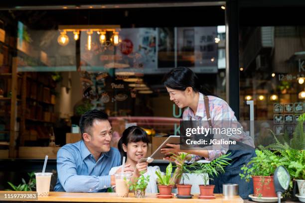 vater und tochter mit kontaktlosem bezahlen in einem café - asian family cafe stock-fotos und bilder