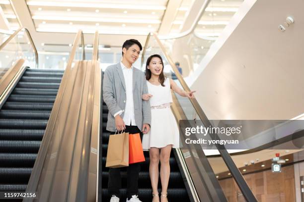 young couple shopping in a mall - yongyuan hongkong stock pictures, royalty-free photos & images