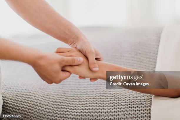 a woman receives a hand massage from a professional massage therapist - hand massage stock pictures, royalty-free photos & images